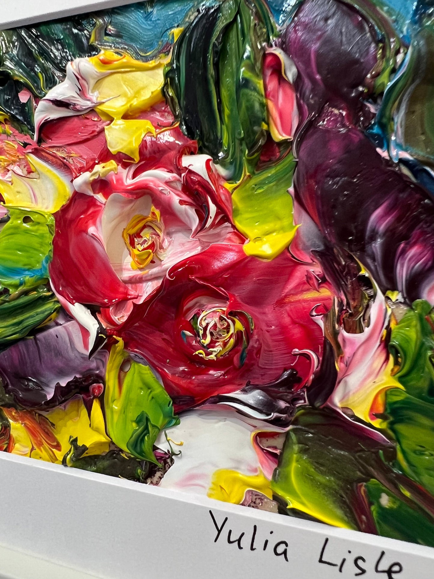 Small framed original impasto oil painting by Yulia Lisle featuring richly textured crimson flowers surrounded by vibrant green foliage, created with thick palette knife strokes and presented in a white frame. Artwork by Yulia Lisle is available at The Acorn Gallery in Pocklington. Shop online or call us on 01759 307652.