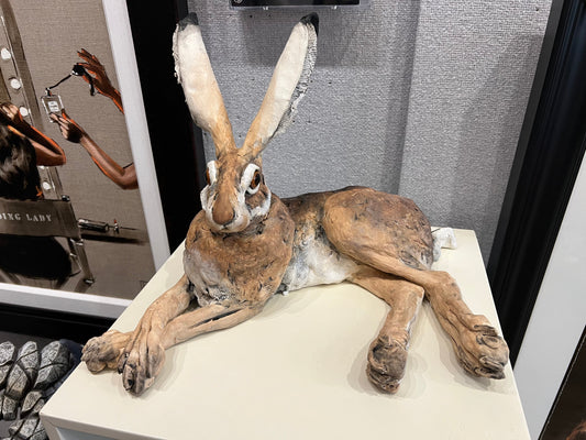 Lying Down Hare Paws Crossed ceramic sculpture by Louise Brown, original artwork, 10x16x13 inches.