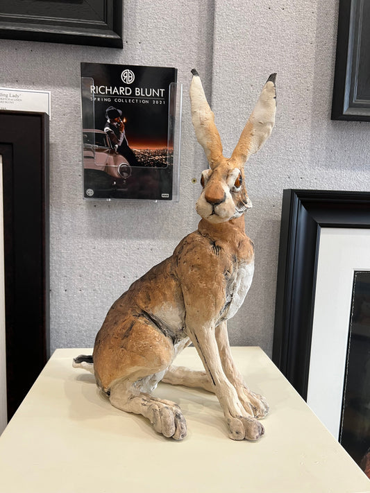 Small sitting ceramic hare sculpture by Louise Brown, head turned, 16" high