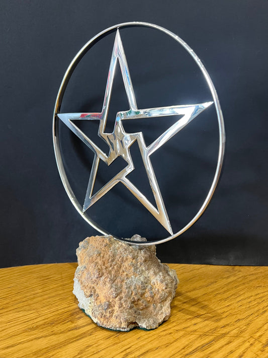Stainless steel star in a stainless steel ring mounted on a fine looking piece of rock. Sculpture by Lancastrian sculptor Malcolm Hull and available at The Acorn Gallery in Pocklington. Call 01759 307652.