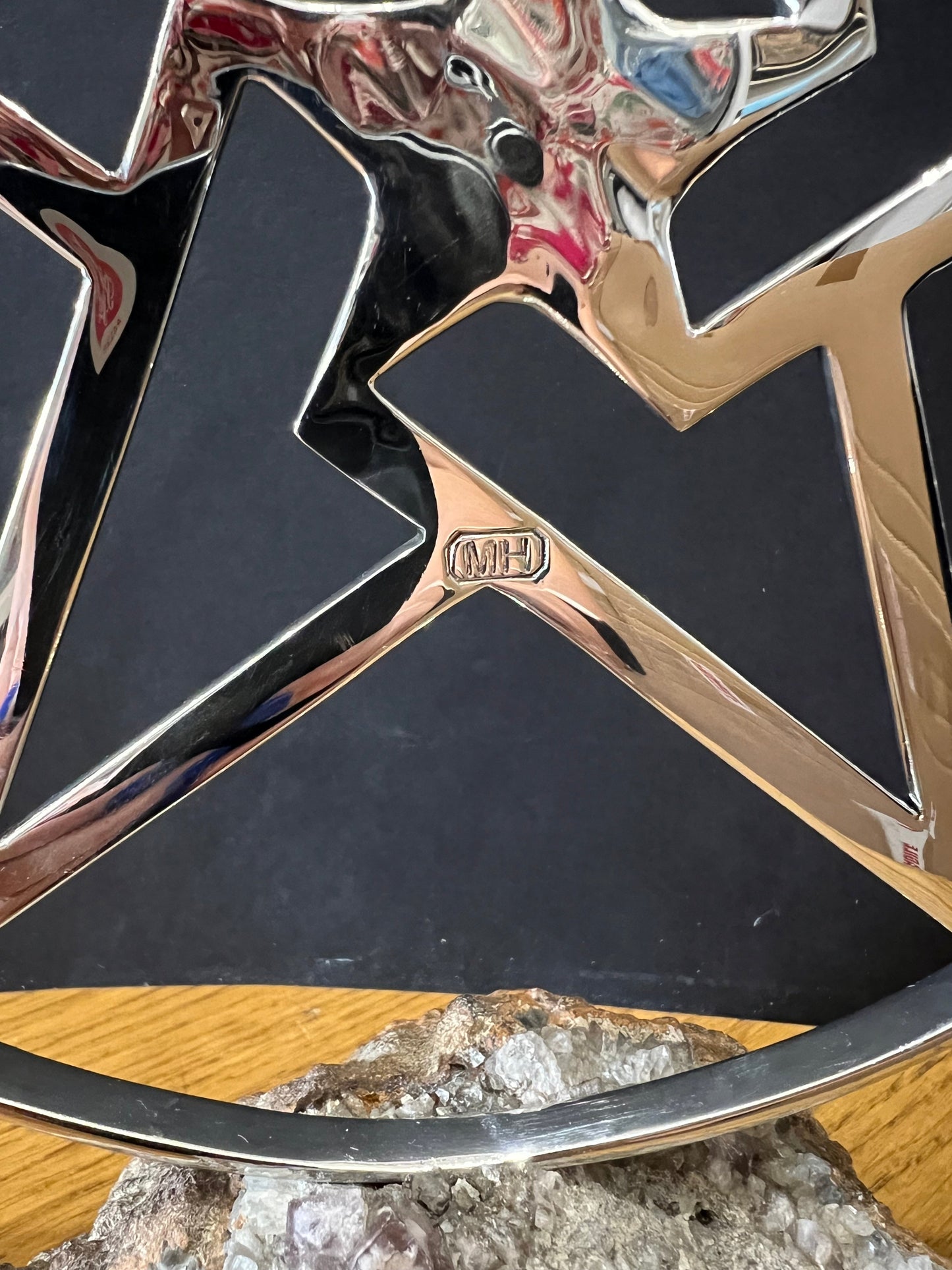 Close up of the makers mark on a stainless steel star in a stainless steel ring mounted on a fine looking piece of rock. Sculpture by Lancastrian sculptor Malcolm Hull and available at The Acorn Gallery in Pocklington. Call 01759 307652.