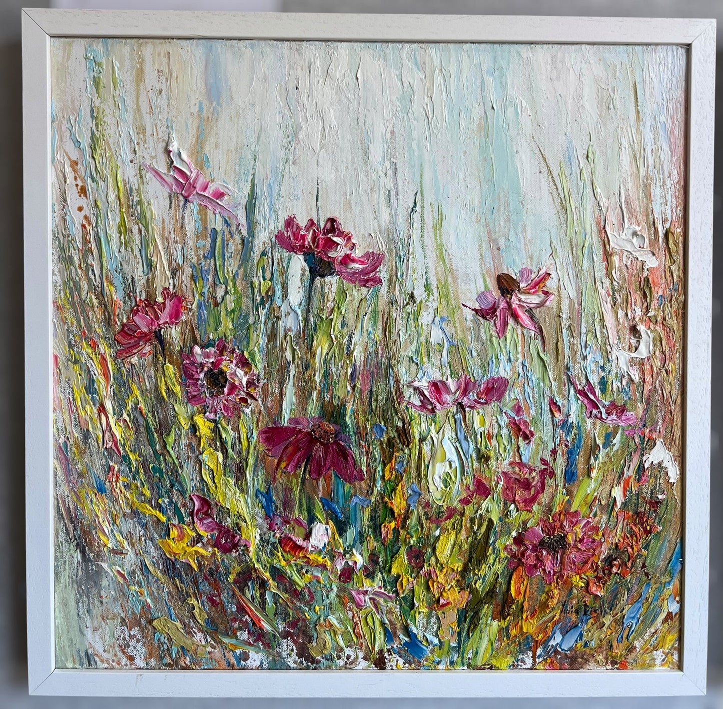Original textured oil painting of a colourful wildflower meadow with pink, white and yellow blooms against a soft pastel background, created with expressive impasto by Yulia Lisle.