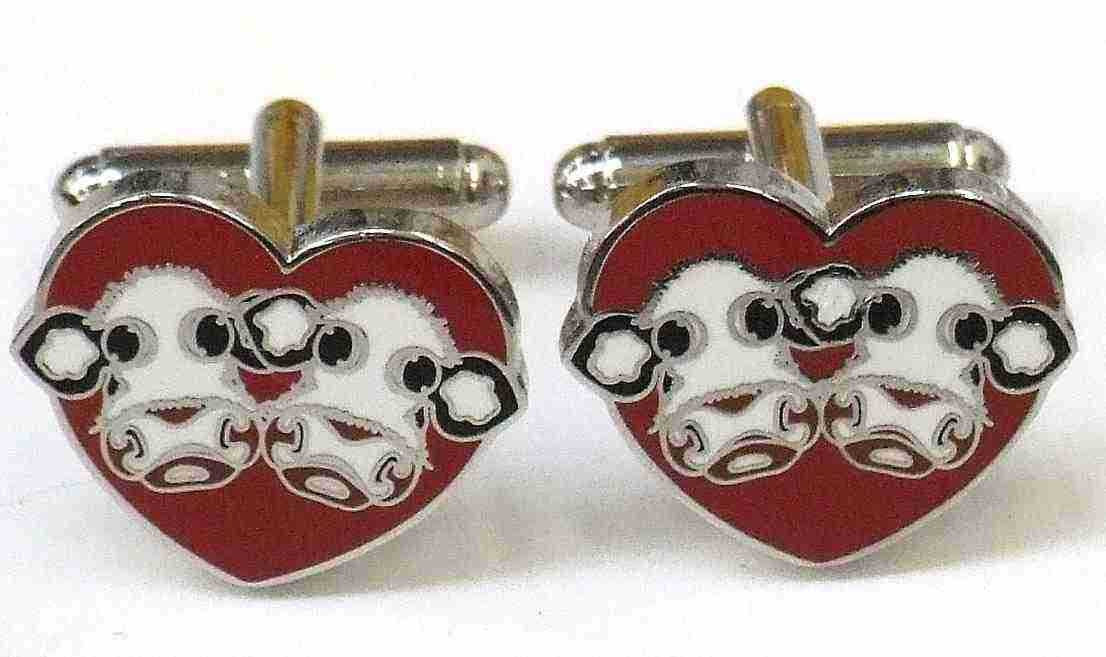 Pair of Caroline Shotton heart-shaped cufflinks with cow design on red background