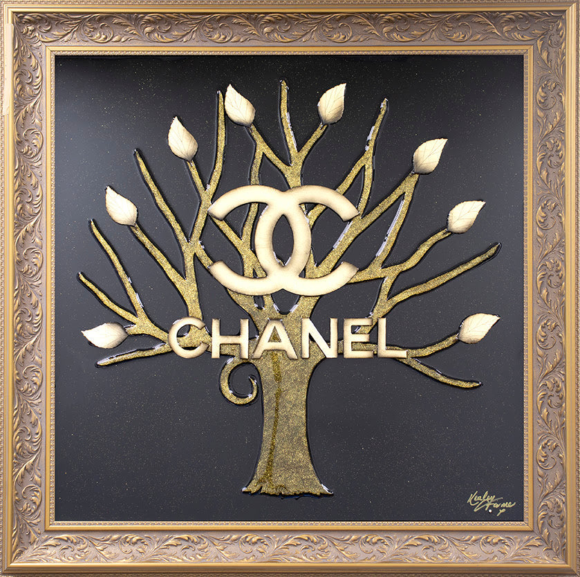 Mixed-media Chanel tree sculpture by Kealey Farmer, with gold leaves, logo and branches on black glass in an ornate gold frame.