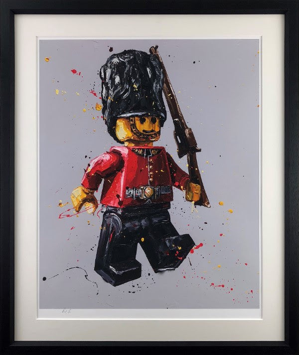 Framed giclée paper print by Paul Oz depicting a red-coated toy soldier with a tall black bearskin hat and rifle.