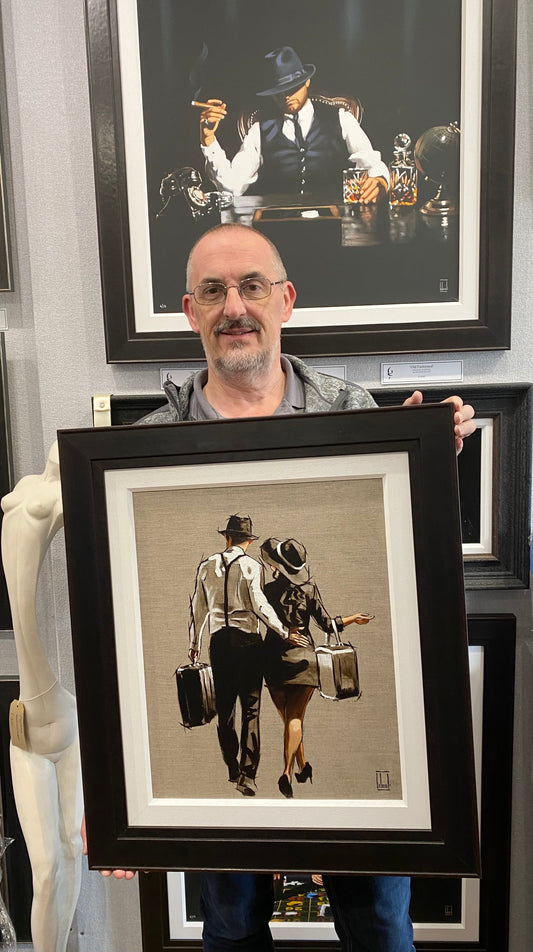 Man holding framed original oil on linen artwork A Weekend Away by Richard Blunt
