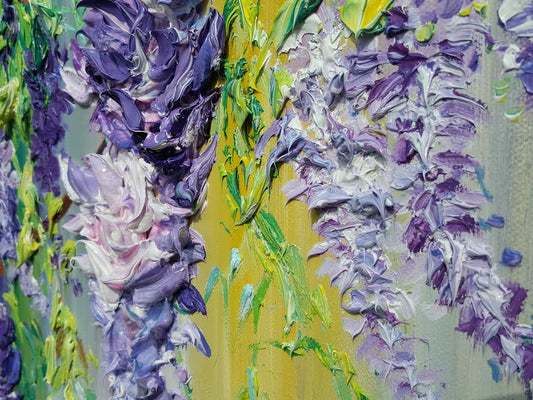 Close-up of heavily textured vibrant oil painting by Yulia Lisle on box canvas with purple and green floral elements
