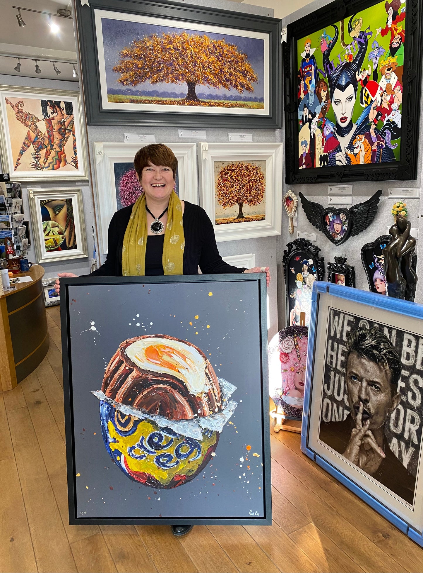 Woman holding Paul Oz hand embellished canvas artwork "How Do You Eat Yours?" in art gallery setting