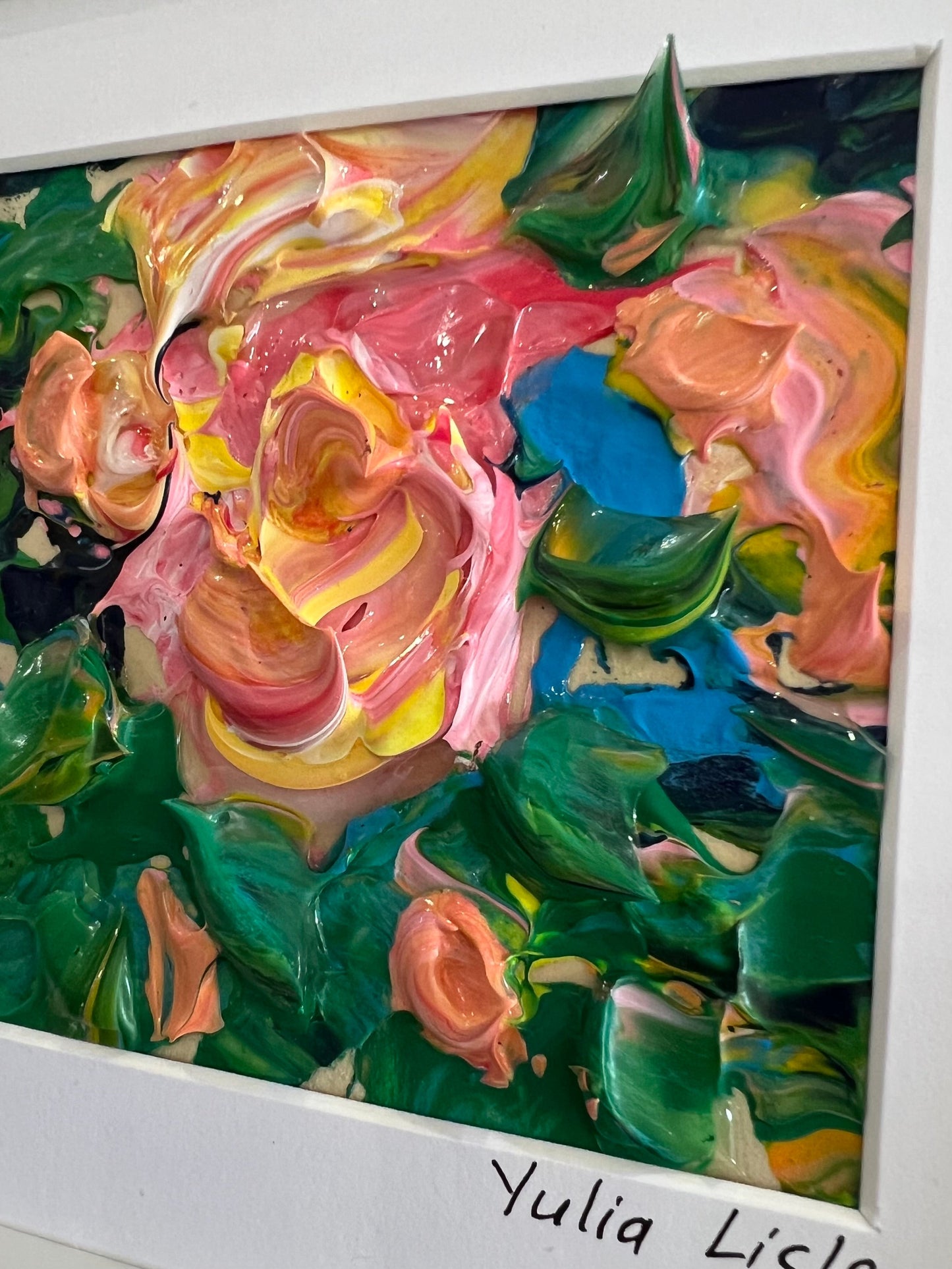 Small framed original impasto oil painting by Yulia Lisle featuring a softly textured pink flower surrounded by lush green foliage, painted with expressive palette knife strokes and rich layers of oil paint. Artwork by Yulia Lisle and available at The Acorn Gallery in Pocklington where you can shop online or call us on 01759 307652.
