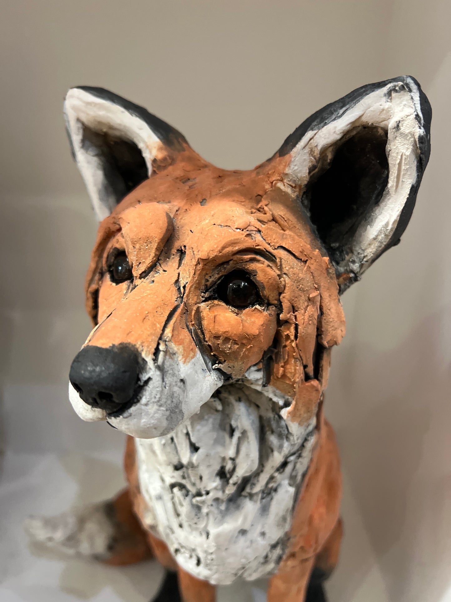 Close-up of a clay fox figurine with a neutral background by Louise Brown at The Acorn Gallery in Pocklington. Call 01759 307652. 