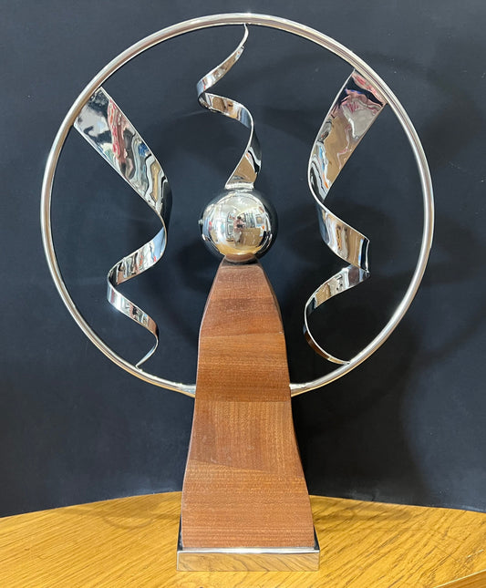 Stainless steel ring sculpture with stainless steel ribbons mounted on a beautiful mahogany pillar with a stainless steel base. Original sculpture by Lancastrian sculptor Malcolm Hull and available at The Acorn Gallery in Pocklington. Call 01759 307652.
