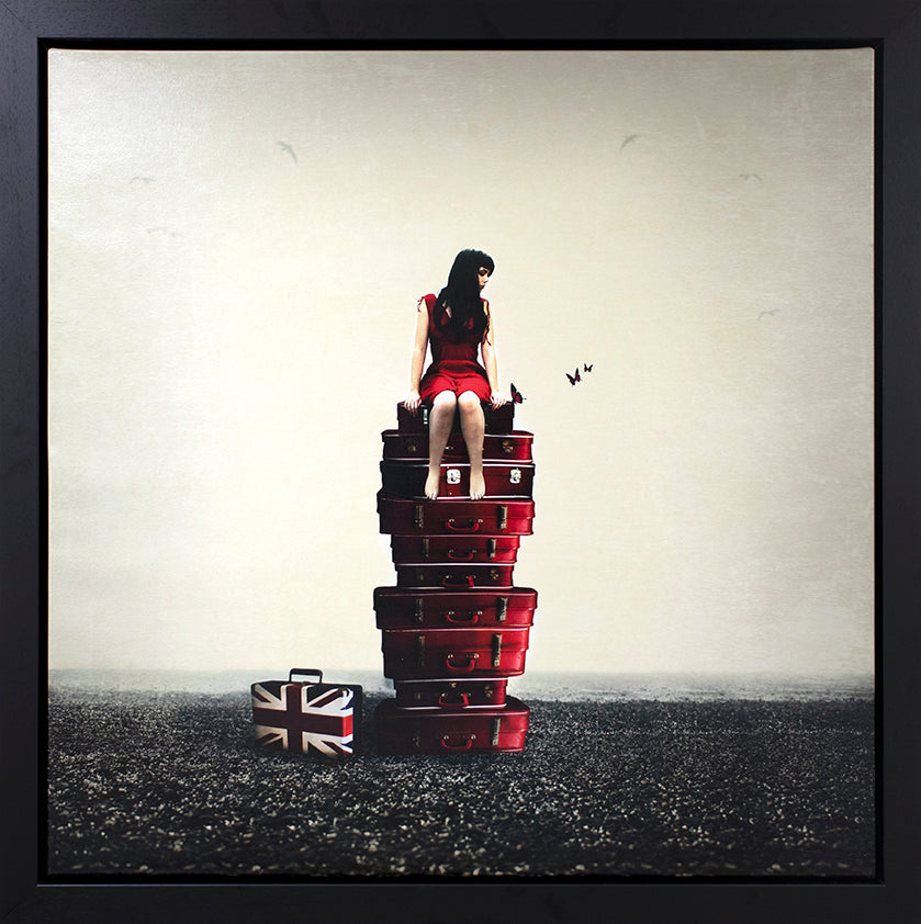 Woman sitting on a stack of suitcases with a Union Jack design, against a plain background. Original painting by Mchelle Mackie at The Acorn Gallery in Pocklington. Call 01759 307652.