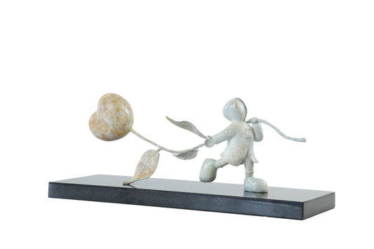 Statue of a child with a heart-shaped balloon on a white background. Sculpture Just Love by Mackenzie Thorpe at The Acorn Gallery. Call 01759 307652.