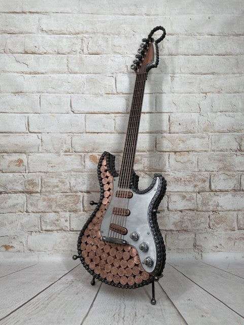 Heads and Tails metal guitar sculpture by Paul Southwell, inspired by a Fender Stratocaster and featuring British 1p and 2p coins