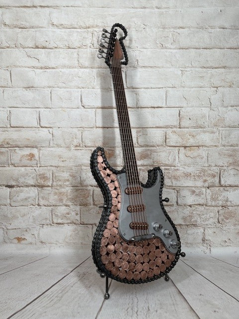 Heads and Tails metal guitar sculpture by Paul Southwell, inspired by a Fender Stratocaster and featuring British 1p and 2p coins