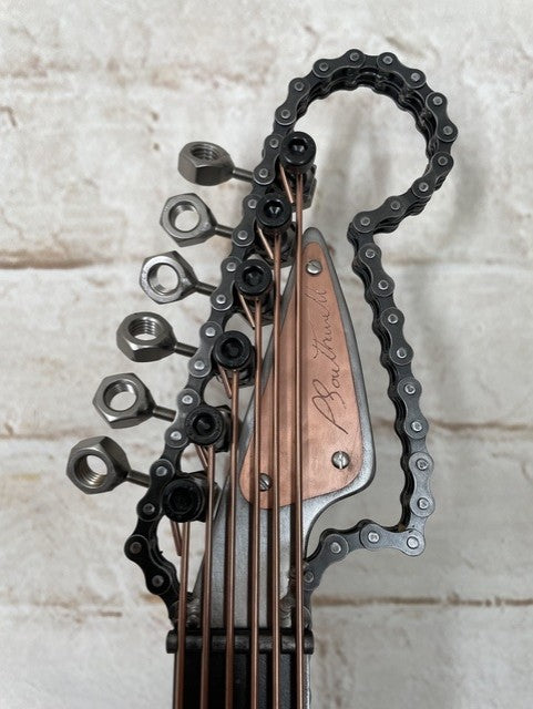 Heads and Tails metal guitar sculpture by Paul Southwell, inspired by a Fender Stratocaster and featuring British 1p and 2p coins