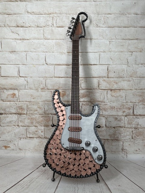 Heads and Tails metal guitar sculpture by Paul Southwell, inspired by a Fender Stratocaster and featuring British 1p and 2p coins