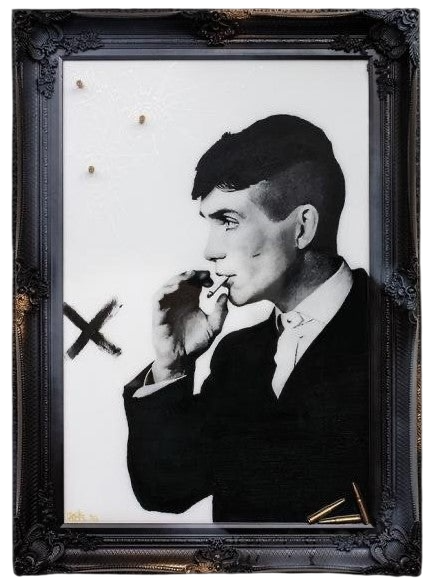Artwork by Ghost featuring the Peaky Blinders character Tommy Shelby. It is titled Strike When Your Enemy Is Weak, and comes in a stunning black and gold ornate frame, embellished with shell casings! Shop at The Acorn Gallery, Pocklington. Buy online or call 01759 307652.