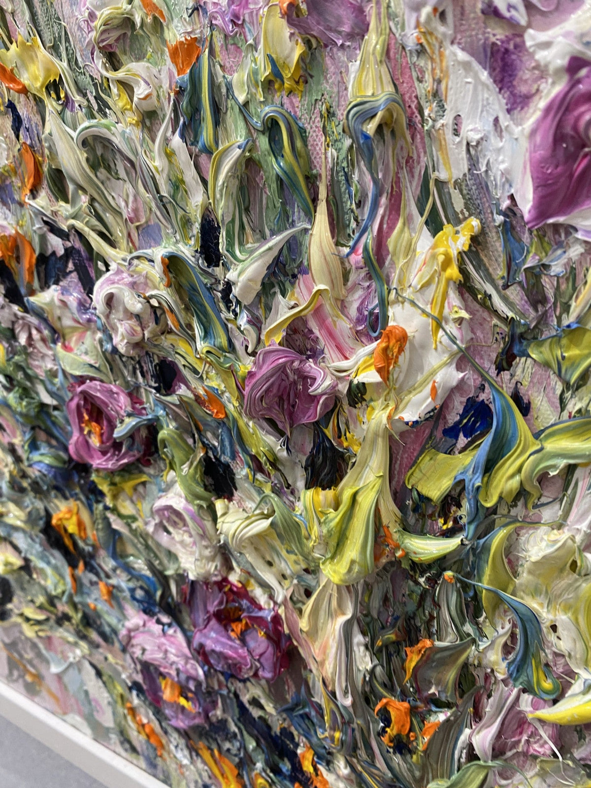 Close Up of Emotions an original floral painting by Yulia Lisle featuring richly textured pink, purple, white and yellow flowers in a white frame.