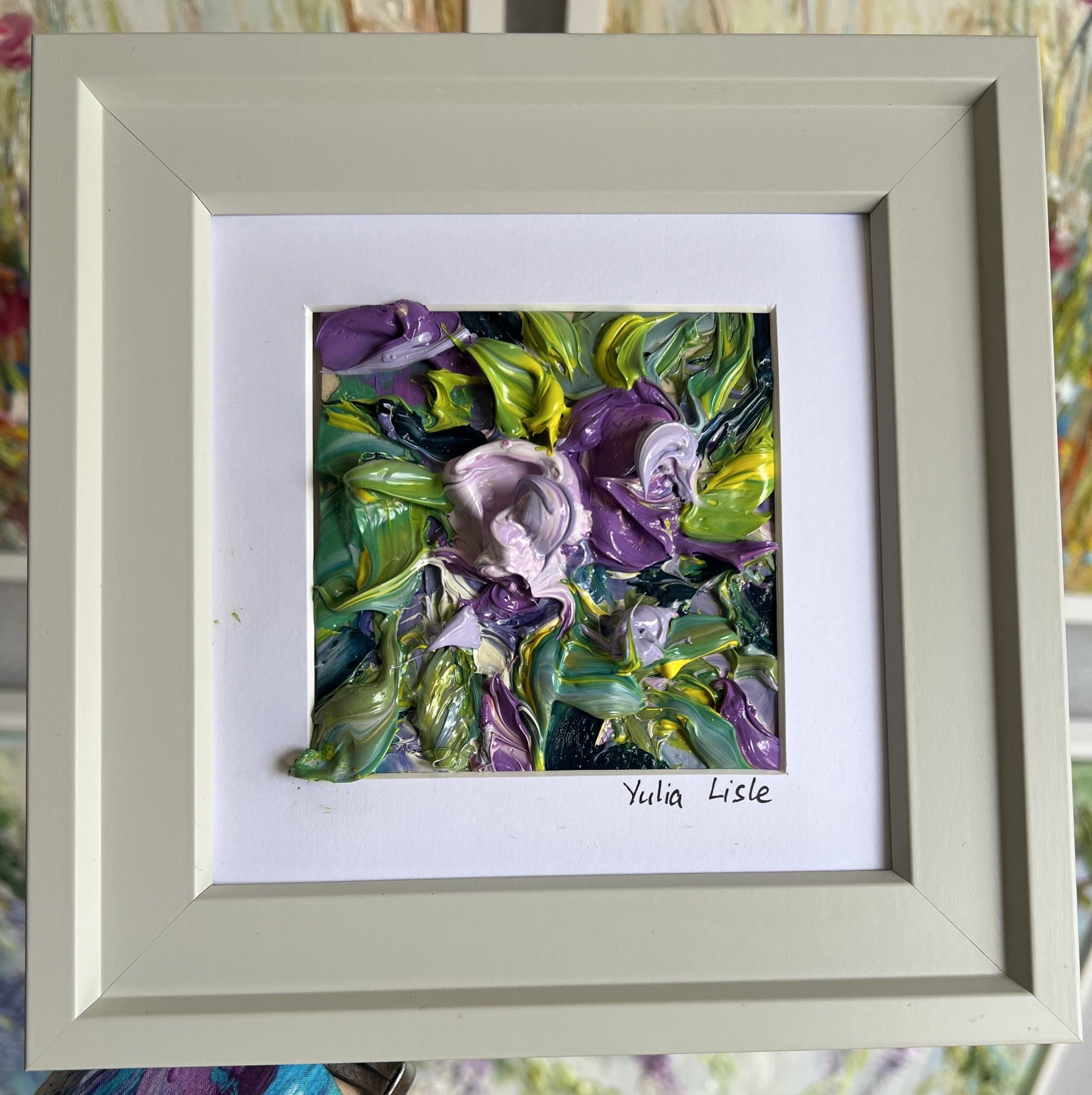 Small framed original impasto oil painting by Yulia Lisle featuring richly textured purple flowers surrounded by vibrant green foliage, created with expressive palette knife strokes and thick layers of oil paint. Artwork by Yulia Lisle and available at The Acorn Gallery in Pocklington where you can shop online or call us on 01759 307652.