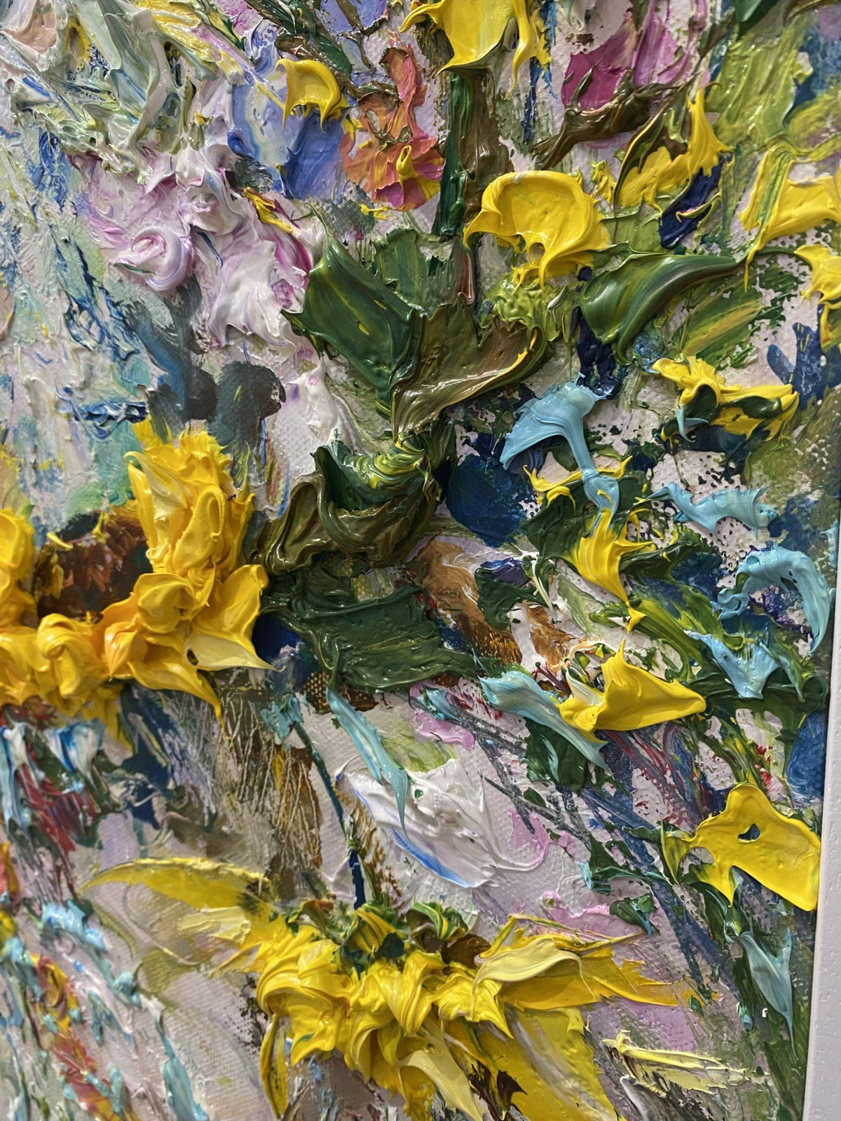 A Close Up of Radiant Resilience original painting by Yulia Lisle featuring richly textured yellow sunflowers surrounded by colourful flowers and foliage in a white frame.